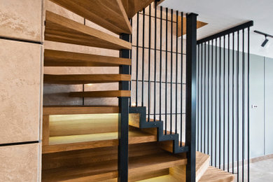На фото: п-образная деревянная лестница среднего размера в современном стиле с деревянными ступенями, металлическими перилами и панелями на стенах