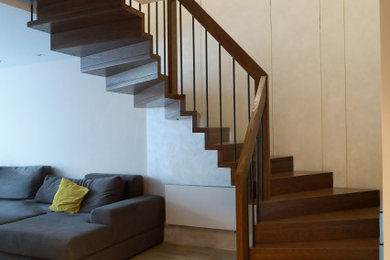 На фото: угловая деревянная лестница среднего размера в современном стиле с деревянными ступенями и перилами из смешанных материалов с