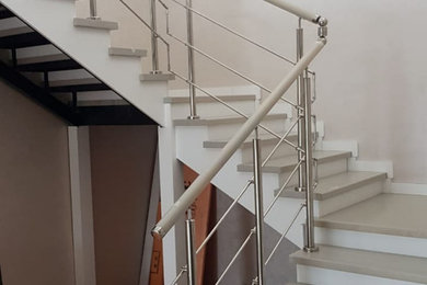 Идея дизайна: изогнутая деревянная лестница среднего размера в современном стиле с деревянными ступенями и металлическими перилами
