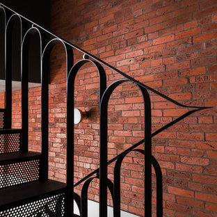 Idées déco pour un escalier moderne en L de taille moyenne avec des marches en métal, des contremarches en métal, un garde-corps en métal et un mur en parement de brique.