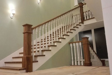 На фото: большая п-образная бетонная лестница в стиле неоклассика (современная классика) с деревянными ступенями и деревянными перилами