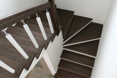 На фото: п-образная деревянная лестница среднего размера в современном стиле с деревянными ступенями и деревянными перилами