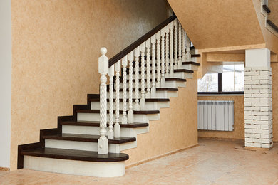 Ejemplo de escalera en U con escalones de madera, contrahuellas de madera y barandilla de madera