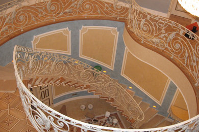 Стильный дизайн: большая винтовая лестница в классическом стиле с деревянными ступенями и металлическими перилами - последний тренд