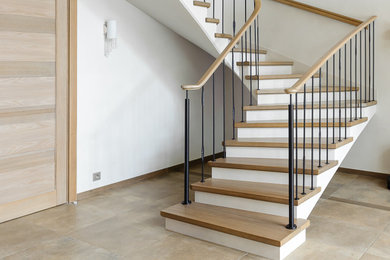 Источник вдохновения для домашнего уюта: большая изогнутая бетонная лестница в современном стиле с деревянными ступенями и перилами из смешанных материалов