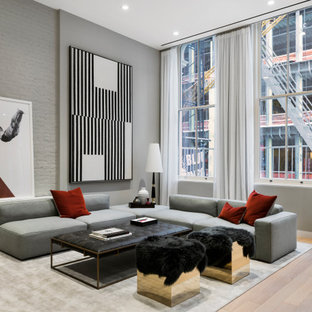 Example of a mid-sized trendy open concept medium tone wood floor and beige floor living room design in New York with gray walls