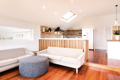 Foto de salón abierto contemporáneo de tamaño medio con paredes blancas, suelo de madera en tonos medios y suelo marrón