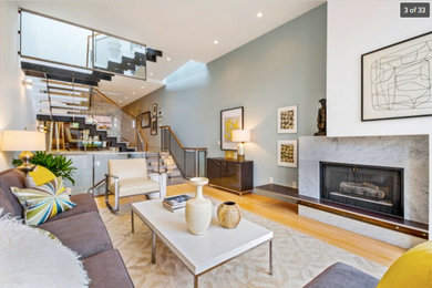 Large trendy open concept bamboo floor living room photo in San Francisco with a standard fireplace and a stone fireplace