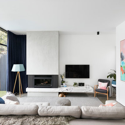 Living room - contemporary enclosed concrete floor living room idea in Melbourne with white walls, a standard fireplace, a concrete fireplace and a wall-mounted tv
