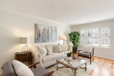 Mittelgroßes, Fernseherloses, Abgetrenntes Klassisches Wohnzimmer ohne Kamin mit beiger Wandfarbe, braunem Holzboden und braunem Boden in Charleston