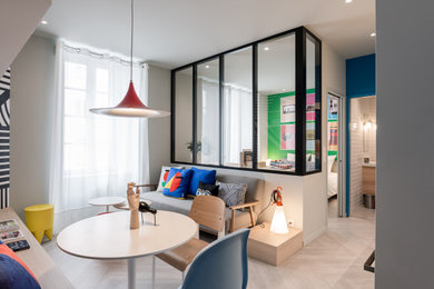 Contemporary open plan living room with a wall mounted tv, light hardwood flooring and beige floors.