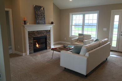 Example of a mid-sized trendy open concept carpeted and beige floor living room design in New York with beige walls, a standard fireplace, a stone fireplace and no tv