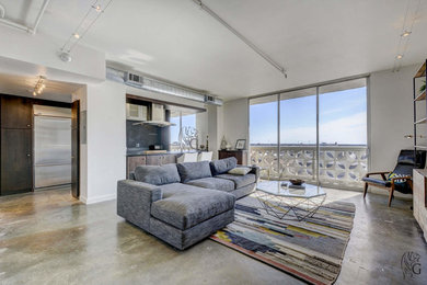 Mid-sized trendy loft-style concrete floor living room photo in Austin