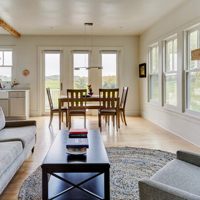Living room - small cottage open concept light wood floor living room idea in Milwaukee with white walls and a hanging fireplace