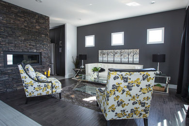 Inspiration for a large contemporary enclosed dark wood floor living room remodel in Other with gray walls, a two-sided fireplace and a stone fireplace