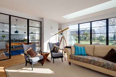 Cette photo montre un grand salon chic fermé avec une salle de réception, un mur blanc, un sol en bois brun et un sol jaune.