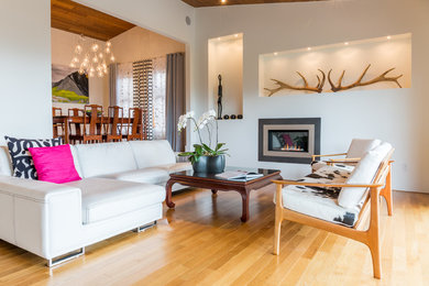Foto de salón abierto contemporáneo de tamaño medio sin televisor con paredes blancas, suelo de madera clara, chimenea lineal y marco de chimenea de yeso