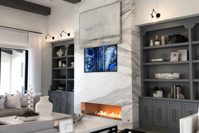 サンディエゴにある広い北欧スタイルのおしゃれなLDK (白い壁、淡色無垢フローリング、標準型暖炉、石材の暖炉まわり、埋込式メディアウォール、グレーの床) の写真