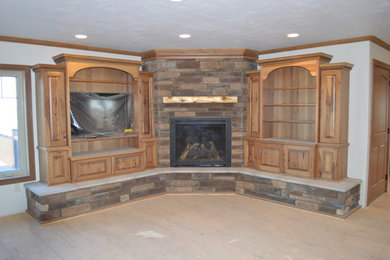 Rustic living room in Other with a corner fireplace and a stone fireplace surround.