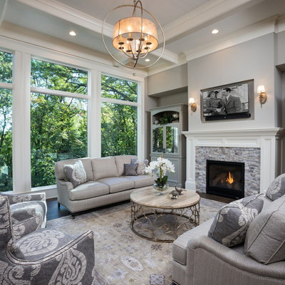 Inspiration for a large transitional formal and open concept dark wood floor and brown floor living room remodel in Minneapolis with gray walls, a standard fireplace, a stone fireplace and a wall-mounted tv
