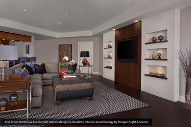 Imagen de salón para visitas abierto grande sin chimenea con paredes púrpuras, suelo de madera oscura y televisor colgado en la pared