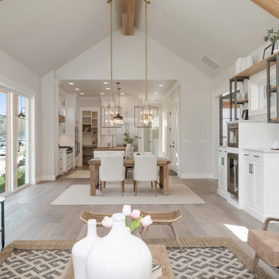 Living room - large country open concept light wood floor and beige floor living room idea in Boise with gray walls, a standard fireplace, a stone fireplace and no tv