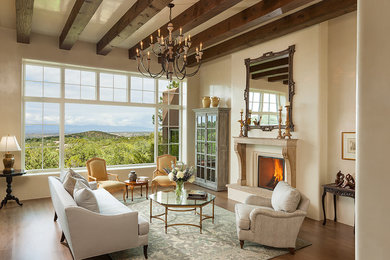 Inspiration for a southwestern formal and open concept medium tone wood floor living room remodel in Albuquerque with beige walls and a standard fireplace