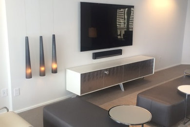 Imagen de salón abierto moderno de tamaño medio sin chimenea con paredes blancas, moqueta y televisor colgado en la pared