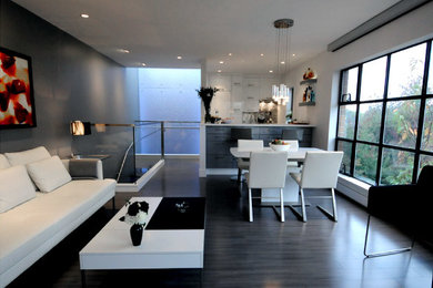 На фото: открытая гостиная комната среднего размера в стиле модернизм с белыми стенами, темным паркетным полом, горизонтальным камином, фасадом камина из камня и серым полом без телевизора с