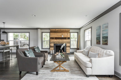 Inspiration for a large open concept dark wood floor living room remodel in Indianapolis with gray walls and a wood fireplace surround
