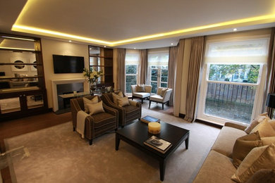 Photo of a medium sized contemporary open plan living room in Essex with a reading nook, beige walls, dark hardwood flooring, a standard fireplace, a stone fireplace surround and a wall mounted tv.