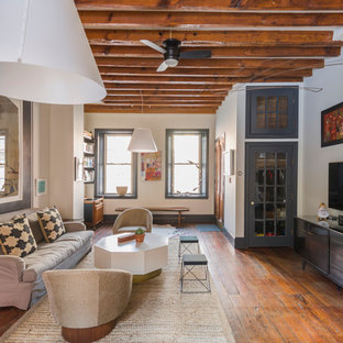 Inspiration for a large eclectic open concept dark wood floor and brown floor living room remodel in Philadelphia with white walls and a wall-mounted tv