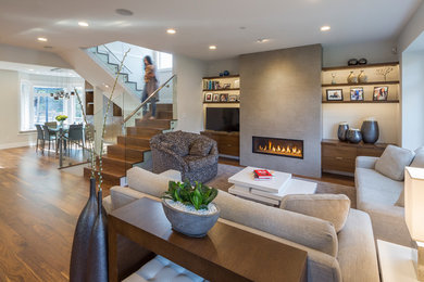 Example of a mid-sized trendy formal and open concept medium tone wood floor and brown floor living room design in Vancouver with beige walls, a ribbon fireplace, a concrete fireplace and a tv stand