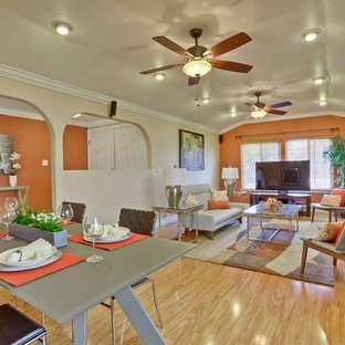 Inspiration for a mid-sized 1950s open concept light wood floor living room remodel in San Francisco with orange walls, a standard fireplace, a plaster fireplace and a tv stand
