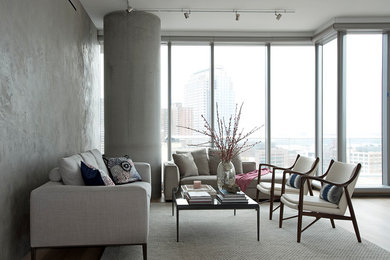 Immagine di un soggiorno design con pareti grigie, pavimento in legno massello medio e pavimento marrone
