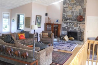 Foto de salón abierto tradicional grande con paredes beige, suelo de madera clara, todas las chimeneas y marco de chimenea de piedra