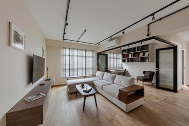 This is an example of a contemporary living room in Singapore with beige walls, medium hardwood flooring and brown floors.