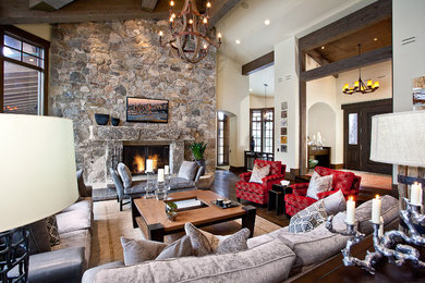 На фото: гостиная комната в классическом стиле с стандартным камином и фасадом камина из камня с