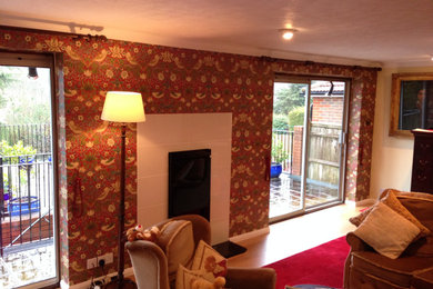 Design ideas for a bohemian living room in Sussex with wallpapered walls.