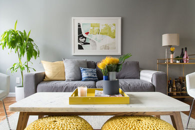 Ispirazione per un soggiorno minimalista di medie dimensioni e aperto con pareti grigie, pavimento in legno massello medio e TV a parete