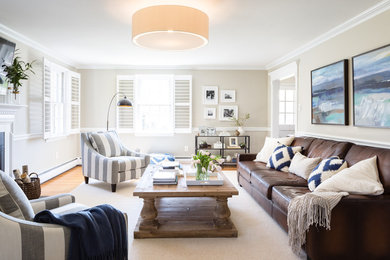 Klassisches Wohnzimmer mit beiger Wandfarbe, hellem Holzboden, Kamin und TV-Wand in Philadelphia