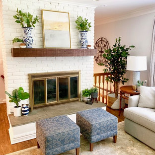 Example of a mid-sized country enclosed medium tone wood floor and brown floor living room design in New York with a standard fireplace, a brick fireplace, a wall-mounted tv and blue walls