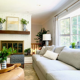 Example of a mid-sized farmhouse enclosed medium tone wood floor and brown floor living room design in New York with a standard fireplace, a brick fireplace, a wall-mounted tv and blue walls