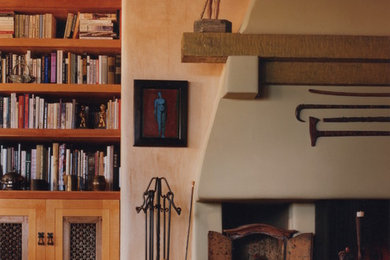 Example of a mid-sized eclectic open concept living room library design in Albuquerque with white walls, a standard fireplace and a plaster fireplace