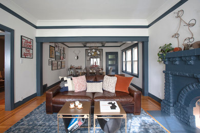Example of a mid-sized eclectic open concept medium tone wood floor living room design in San Francisco with white walls, a standard fireplace, a brick fireplace and no tv