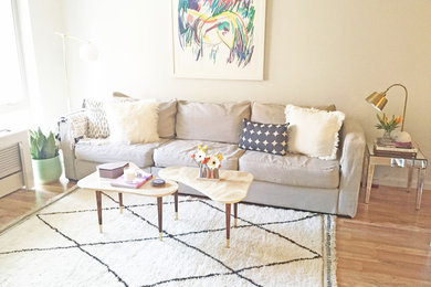 Mittelgroßes, Offenes Modernes Wohnzimmer mit weißer Wandfarbe, braunem Holzboden und freistehendem TV in Portland