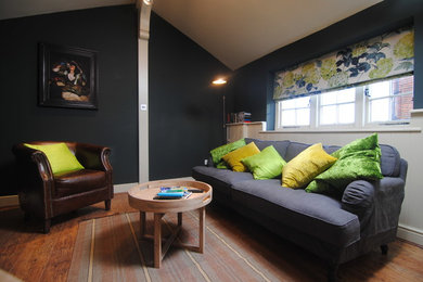 Foto de salón contemporáneo con paredes verdes, suelo laminado y suelo marrón
