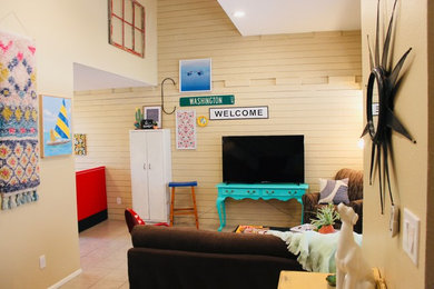 Ejemplo de salón abierto bohemio de tamaño medio con paredes beige, suelo de baldosas de cerámica, televisor independiente y suelo beige
