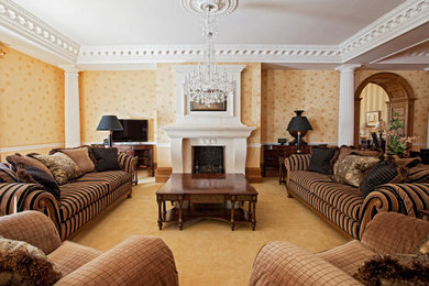 This is an example of a large traditional living room in Surrey with yellow walls, carpet, a standard fireplace, a stone fireplace surround and yellow floors.