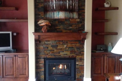 Inspiration for a mid-sized rustic medium tone wood floor and brown floor living room remodel in Seattle with multicolored walls, a standard fireplace, a stone fireplace and a tv stand
